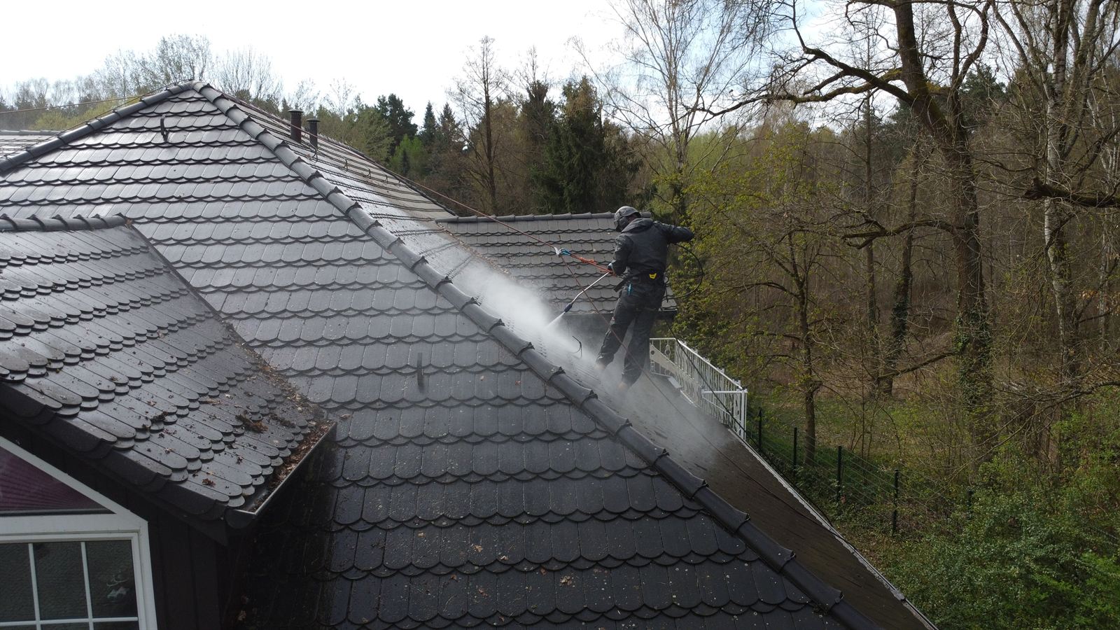 Renoskam-Mitarbeiter bei der professionellen Reinigung eines großen Daches