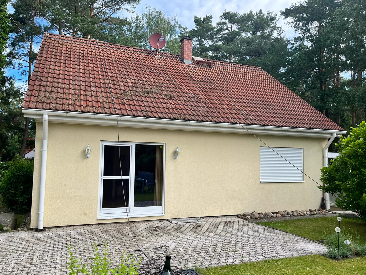 Mit Moos und Ablagerungen verschmutztes Dach vor der Reinigung