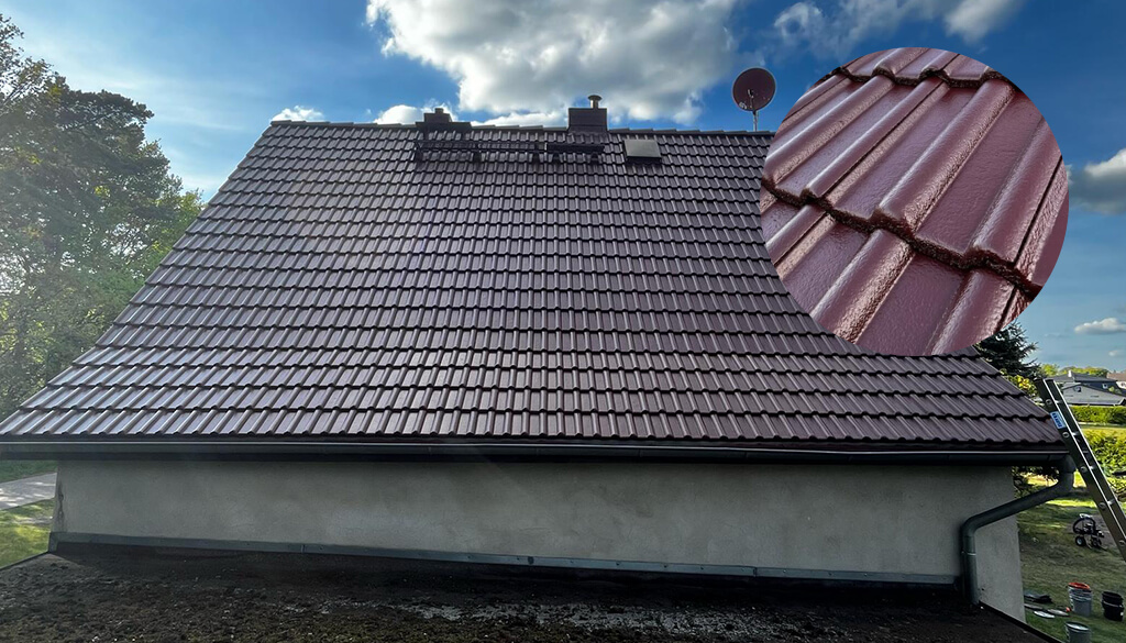Frisch gestrichenes Satteldach mit dunklen Betondachziegeln in gleichmäßiger Farbdeckung, aufgenommen bei Tageslicht - Beispiel für professionelle Dachbeschichtung